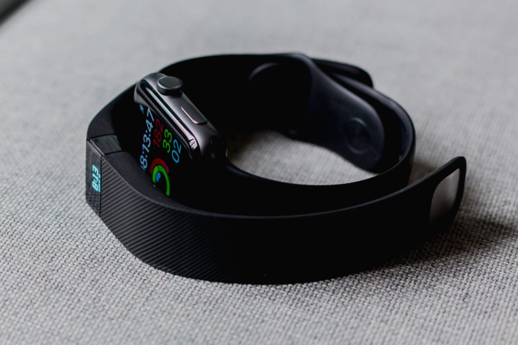 schwarzes Aluminiumgehäuse Apple Watch und schwarze Fitbit-Ladung 2